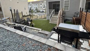 Un quartier résidentiel avec des maisons, une terrasse dotée de mobilier d’extérieur et un petit espace gazonné.