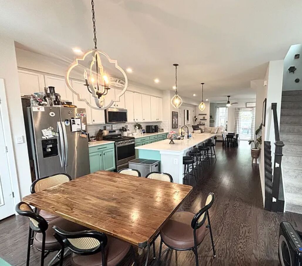 A modern kitchen with a central island, stainless steel appliances, and pendant lighting.