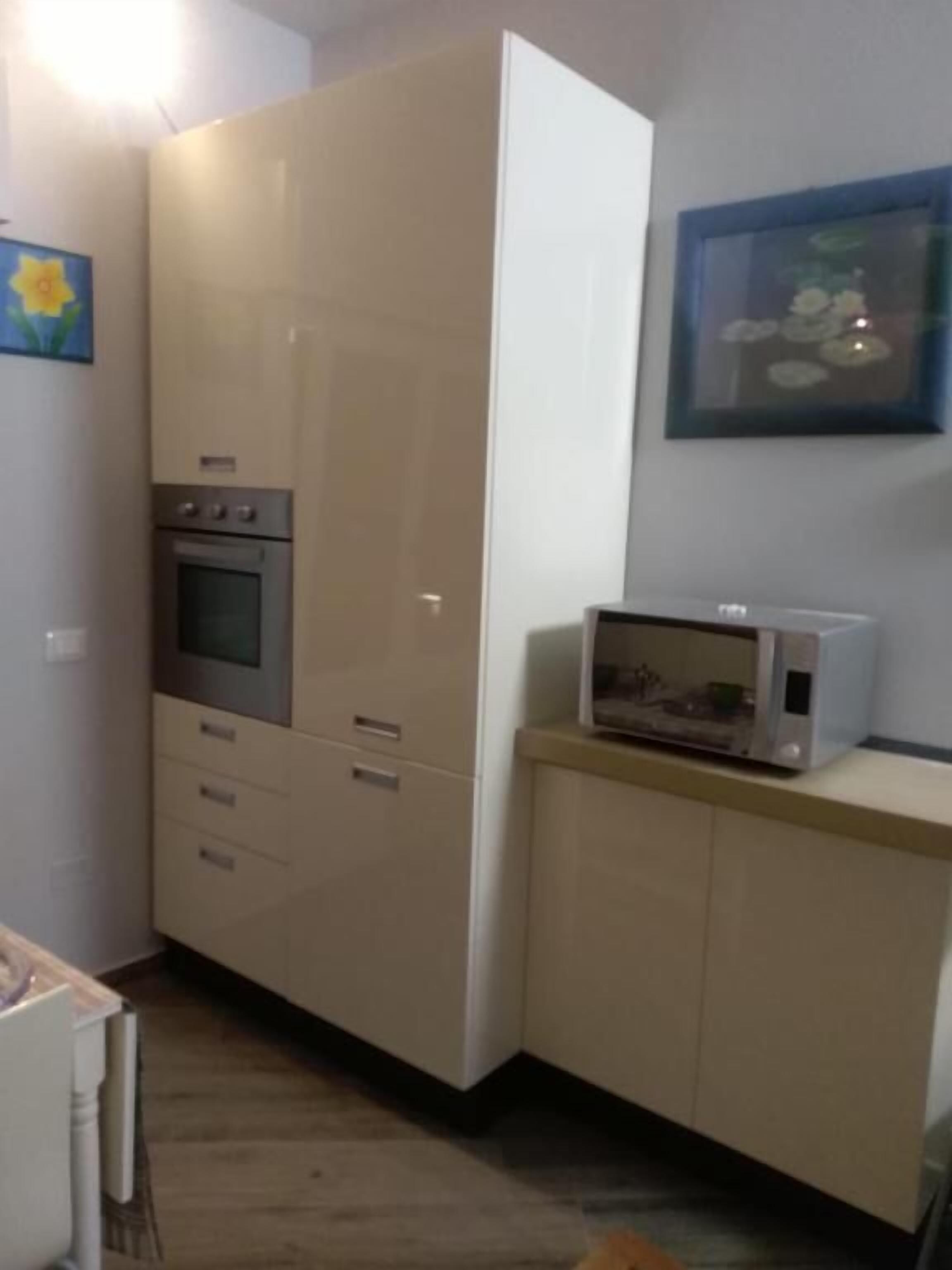 A kitchen with a microwave, oven, and cabinets.