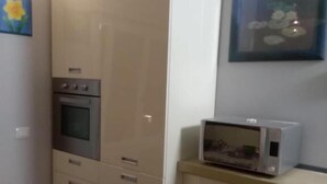 Μια κουζίνα με φούρνο μικροκυμάτων, φούρνο και ντουλάπια.