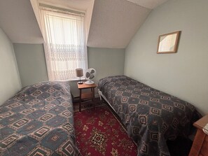 A small, single-room accommodation with two beds, a desk, a chair, and a window with curtains. - The “Dining Room” A 5-bedroom cottage perfect for large families. Clyffe House (Port Sydney)