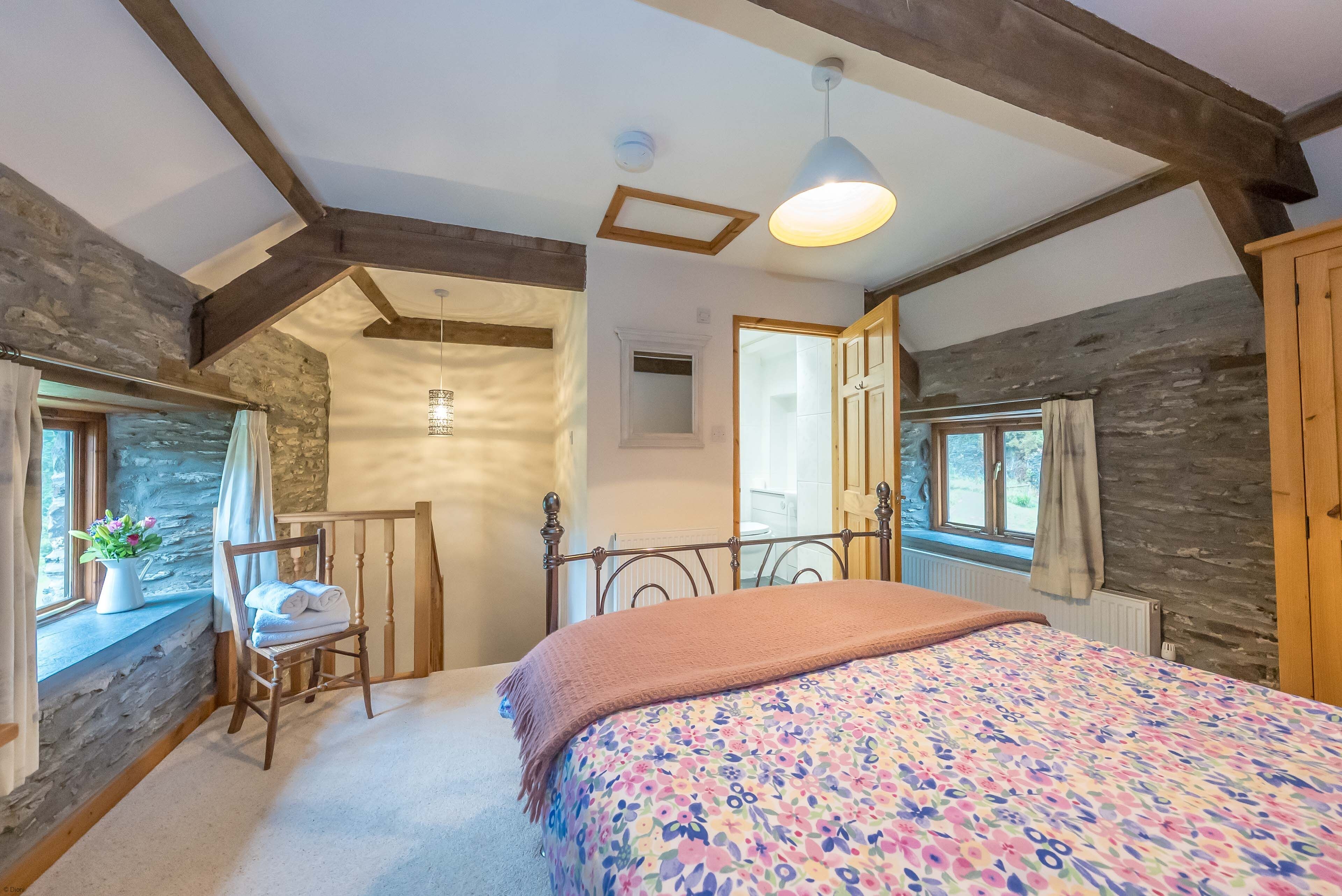 A bedroom with a bed, a chair, a window, and a door.