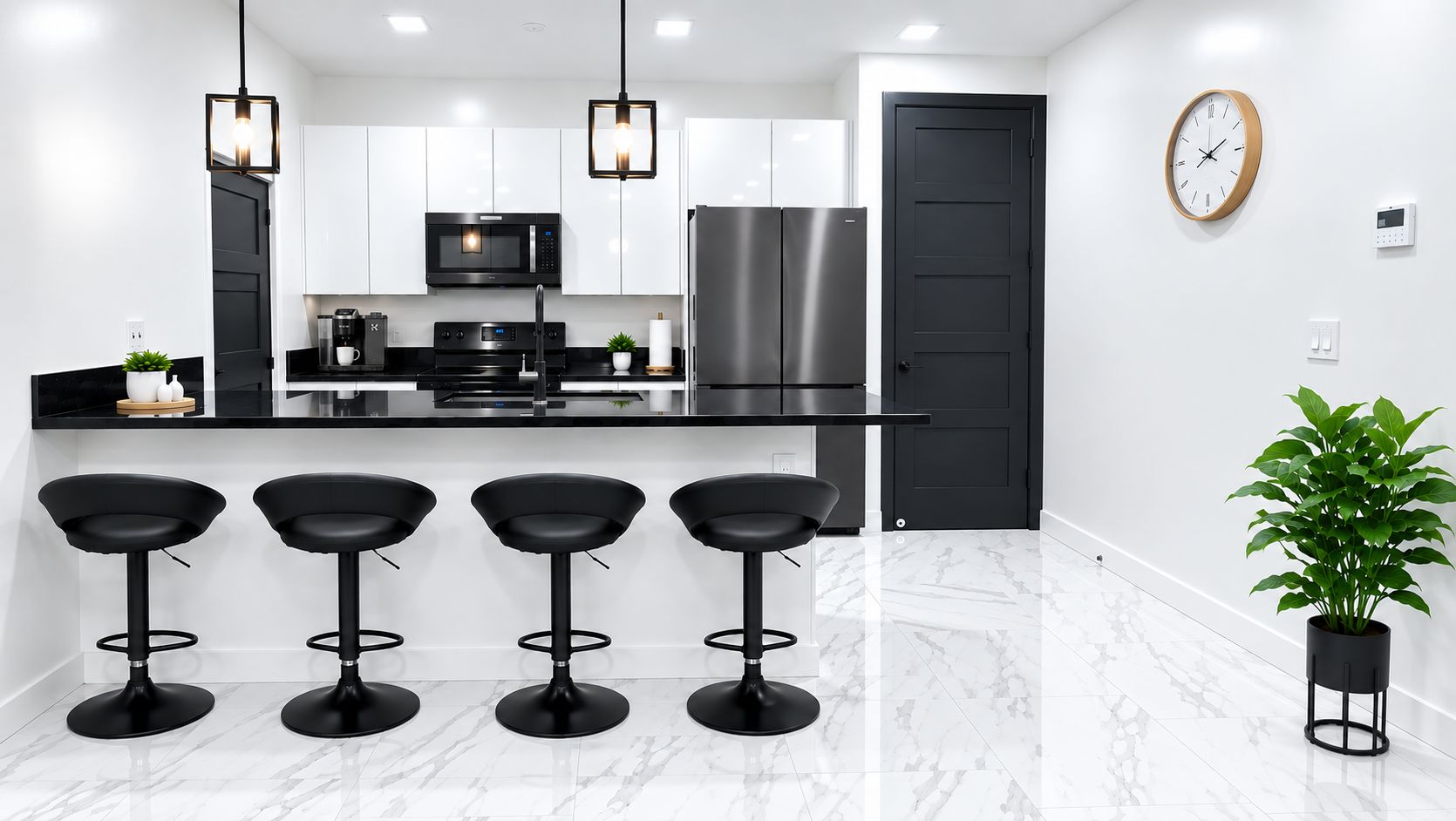 Una cocina moderna con encimera negra, cuatro taburetes negros de bar, un refrigerador de acero inoxidable, un microondas y una planta en maceta.