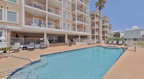 A multi-story hotel with a swimming pool, outdoor seating, and balconies. - Gulf Shores Escape with Breathtaking Views, Beach Days & Unforgettable memories (Gulf Shores)