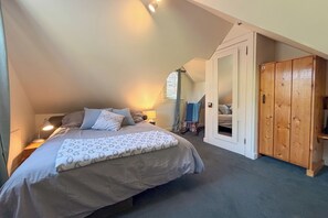 A bedroom with a bed, bedside lamp, and a wardrobe. - The Victorian Garden Retreat (Victoria)