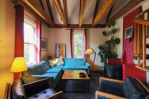 A cozy living room with a blue sofa, a wooden coffee table, and a fireplace. - The Victorian Garden Retreat (Victoria)