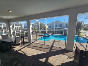 A covered patio area with a pool, outdoor furniture, and a view of neighboring houses. - Marvelous 9-bedroom house with AC in peaceful Davenport (Davenport)