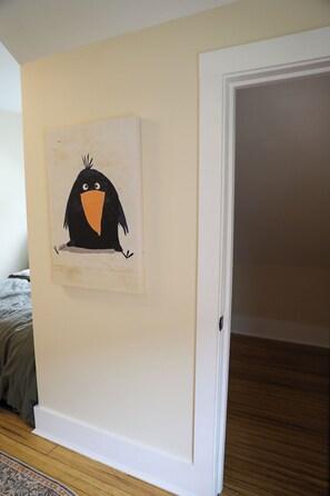 A room with a white door, a wooden floor, and a painting of a black bird on the wall. - The Byrd House — Charming 3-bedroom, 3-livingroom Oceanview house in Wrangell (Wrangell)