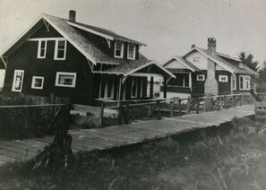 Række af to etagers huse med træterrasse foran.