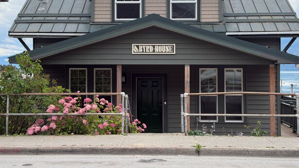 Ein zweistöckiges Gebäude mit einem Schild, auf dem 'BYRD-HOUSE' steht.