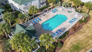 Vista aèria d'un hotel amb piscina, palmeres i gandules.