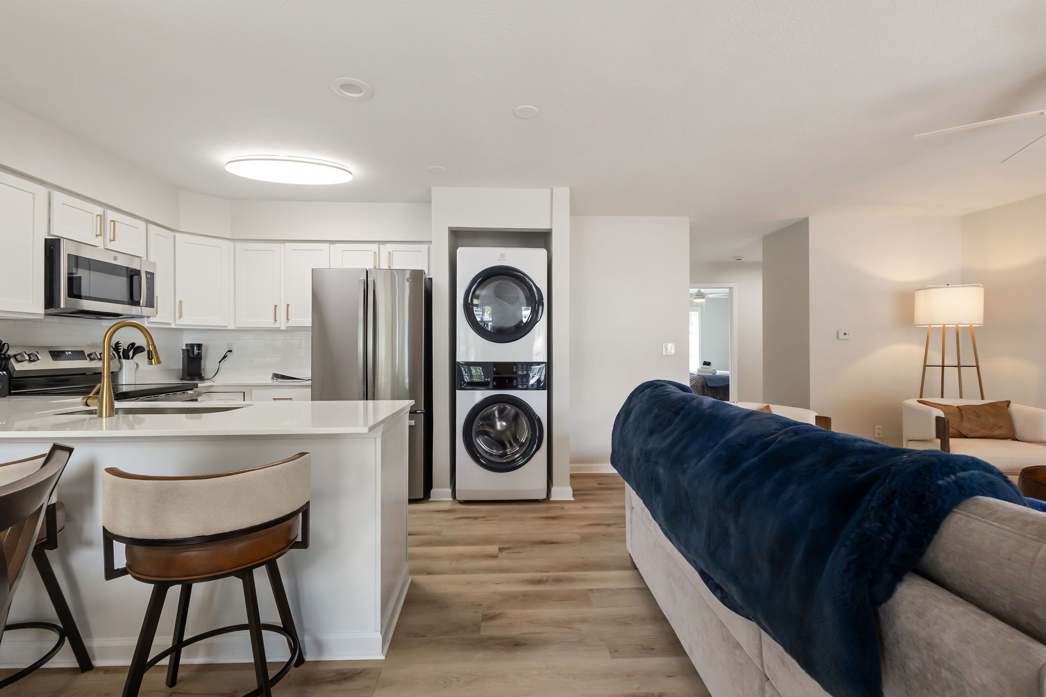 A modern kitchen with a central island, stainless steel appliances, and a built-in washer and dryer.