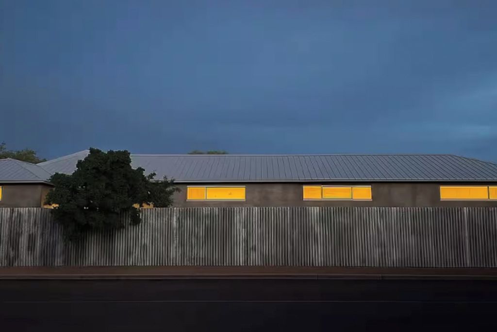 Un bâtiment doté d’un toit en tôle ondulée et d’une clôture en bois.