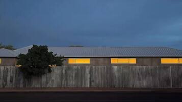 Un bâtiment doté d’un toit en tôle ondulée et d’une clôture en bois.
