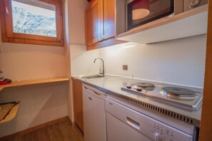 A compact kitchen with a sink, Bosch dishwasher, and a window with a view of a mountainous landscape. - 150m from ski slopes, 1st floor, balcony, tv, ski locker, 32m², Valmorel (Valmorel)