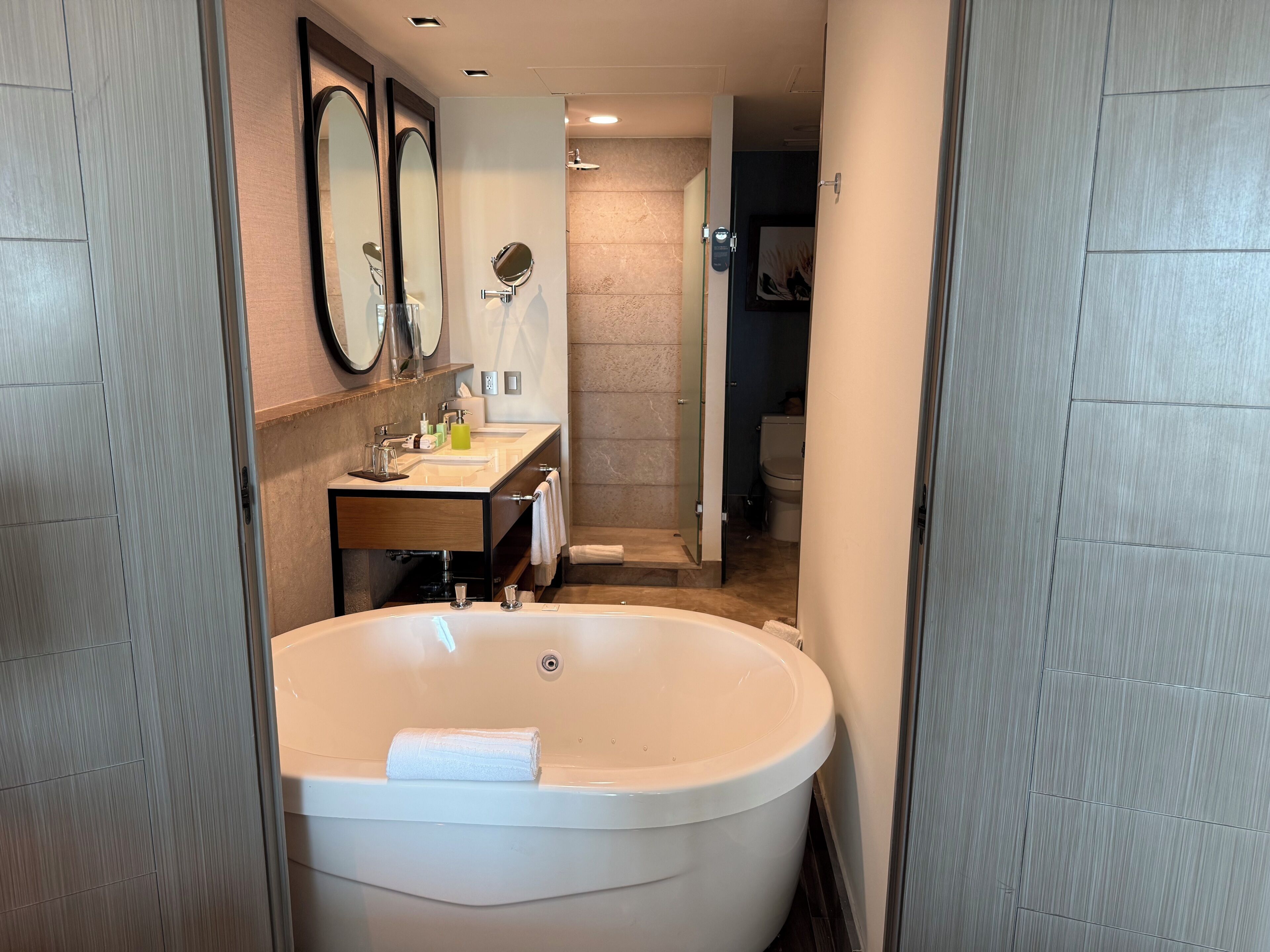 Un bagno moderno con una vasca freestanding, un mobile lavabo con specchio e uno spazio doccia.
