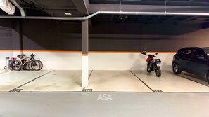 A parking garage with a motorcycle and a car parked in designated spaces. - ASA Itajai Ressacada 3BR Near Br101 Beaches (Itajai)