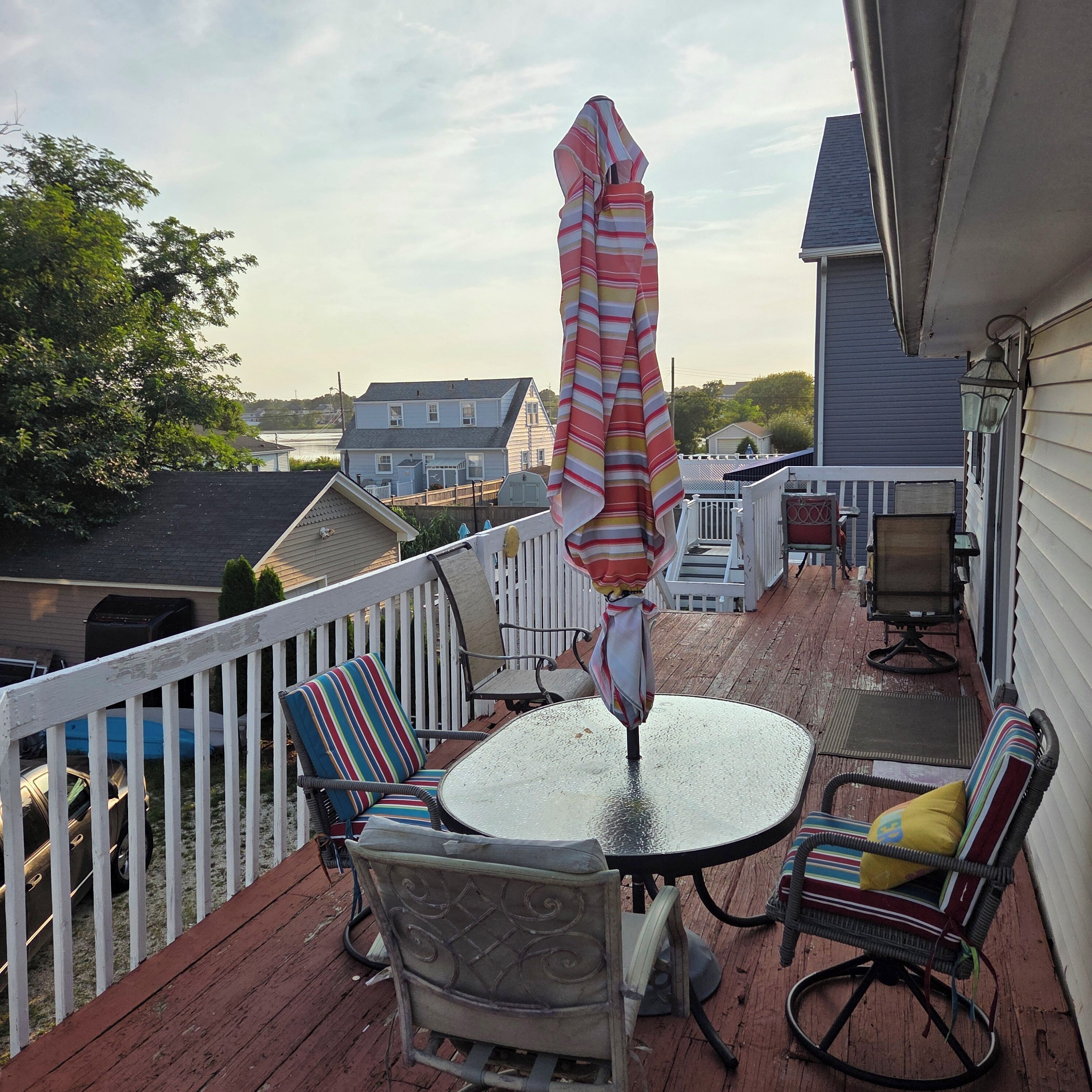 A deck with outdoor furniture, including chairs and a table, and an umbrella.