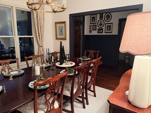 Comedor con una mesa de madera dispuesta para una comida, rodeado de sillas.
