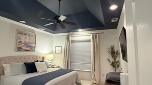 A bedroom with a bed, ceiling fan, bedside table, lamp, window with blinds, and a plant. - Private 4BR Oxford Home Minutes from Ole Miss & Square (Oxford)