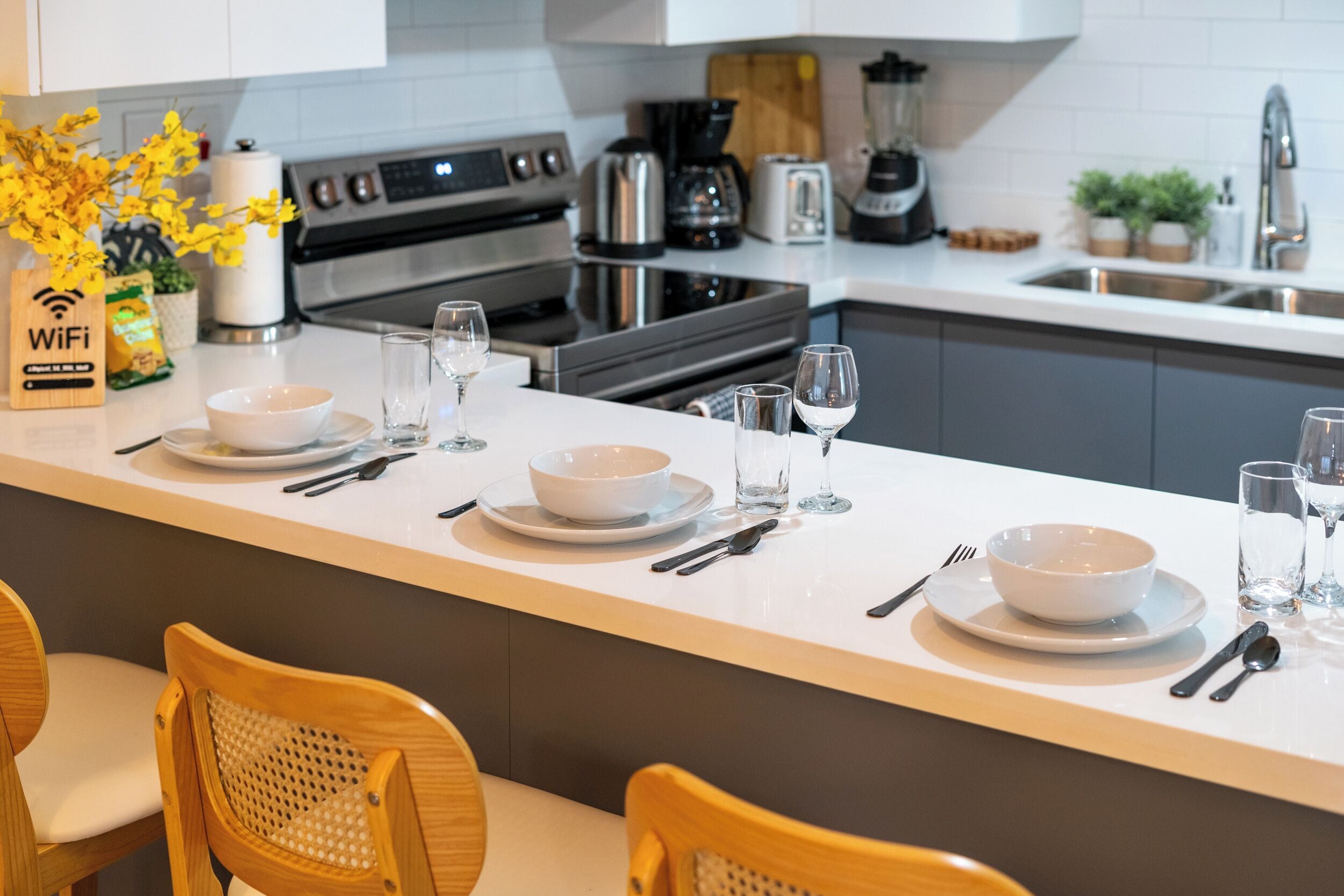 A modern kitchen with a central island, equipped with a coffee maker, toaster, and blender.