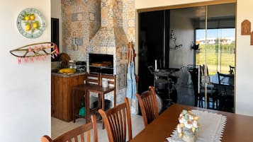 Uma área de refeições com mesa de madeira, cadeiras e um vaso decorativo.