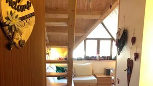 Un intérieur en bois avec un lit, un bureau et une fenêtre.