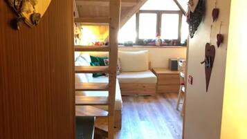 Ein Zimmer mit Holzausstattung, einem Bett, einem Schreibtisch und einem Fenster.