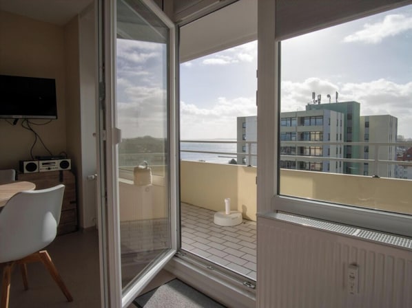 A balcony with a view of buildings and a clear sky. - Holiday Apartment With 1 Bedroom (Grossenbrode)