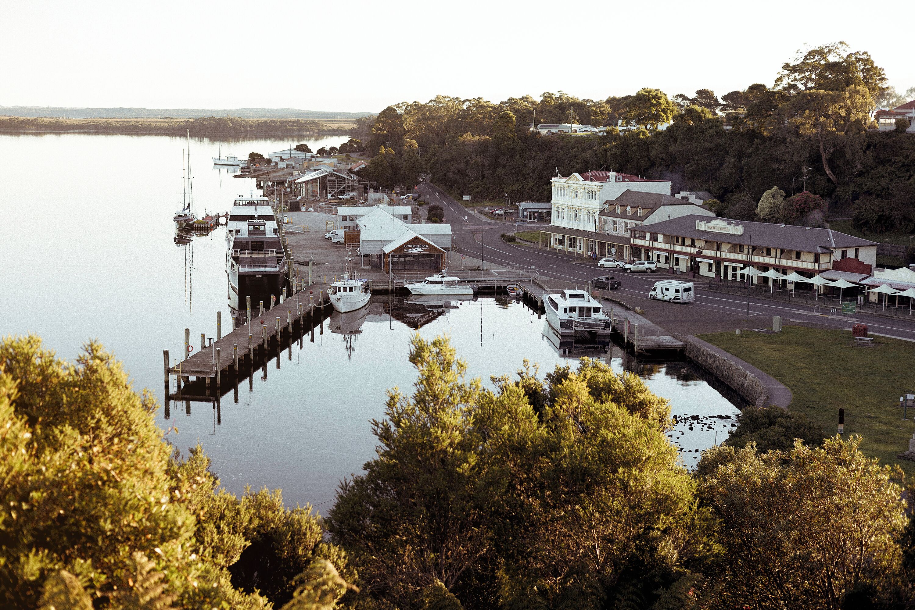 A riverside town with a dock, buildings, and a road.