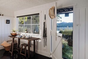 Una cocina con un ventanal grande, mobiliario de madera y vistas a un paisaje natural.
