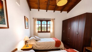 A bedroom with two beds, a window with curtains, a wardrobe, and a lamp. - A cozy and spacious apartment with private access. Pets are welcome. (Río Cuarto)