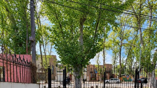 A paved pathway leading to a gated area with a stone wall and a metal fence. - A cozy and spacious apartment with private access. Pets are welcome. (Río Cuarto)