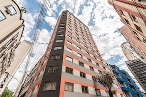 Ein Hochhaus mit mehreren Etagen, das durch modernes Design in Grau, Orange und Weiß gekennzeichnet ist.