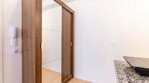 Ein Zimmer mit einem Holzschrank, einem Telefon und einer Arbeitsplatte aus Granit.