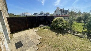 A residential backyard with a stone pathway leading to a wooden fence, a small bush, and a lawn. - Ker Elenn - PLEUBIAN (PLEUBIAN)