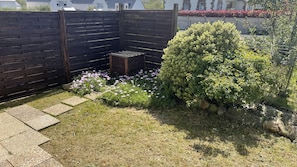 A garden with a wooden fence, a small wooden bench, and various plants. - Ker Elenn - PLEUBIAN (PLEUBIAN)