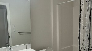 Un baño con lavamanos blanco, inodoro y cortina de ducha.