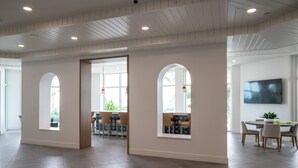 A spacious interior with a high ceiling, large windows, and a modern dining area. - Luxury Fragrance-Free Bayfront Retreat with Saltwater Pool (Clearwater)