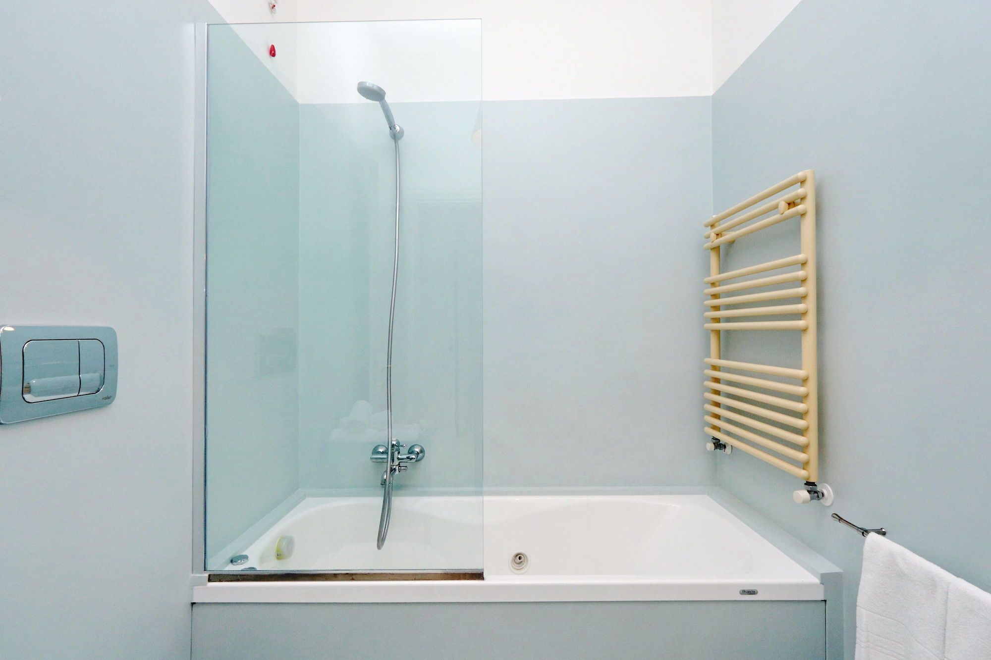 Ein Badezimmer mit einer Duschkabine, einer weißen Badewanne und einem Handtuchhalter.
