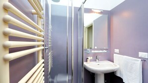 A bathroom with a glass shower enclosure, a white sink, and a towel hanging on a rack. - Fontana Più Stella (Rome)