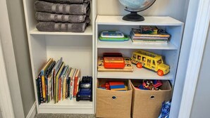 A neatly organized bookshelf with books, a globe, and toys. - "Call Me Old-Fashioned" in Derby & Bourbon Country! (Louisville)