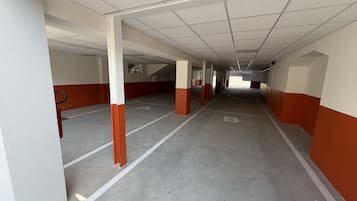 A multi-level parking garage with concrete floors and white and orange walls.