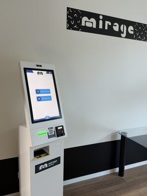 A self-service kiosk with a screen displaying options for check-in and card recovery.