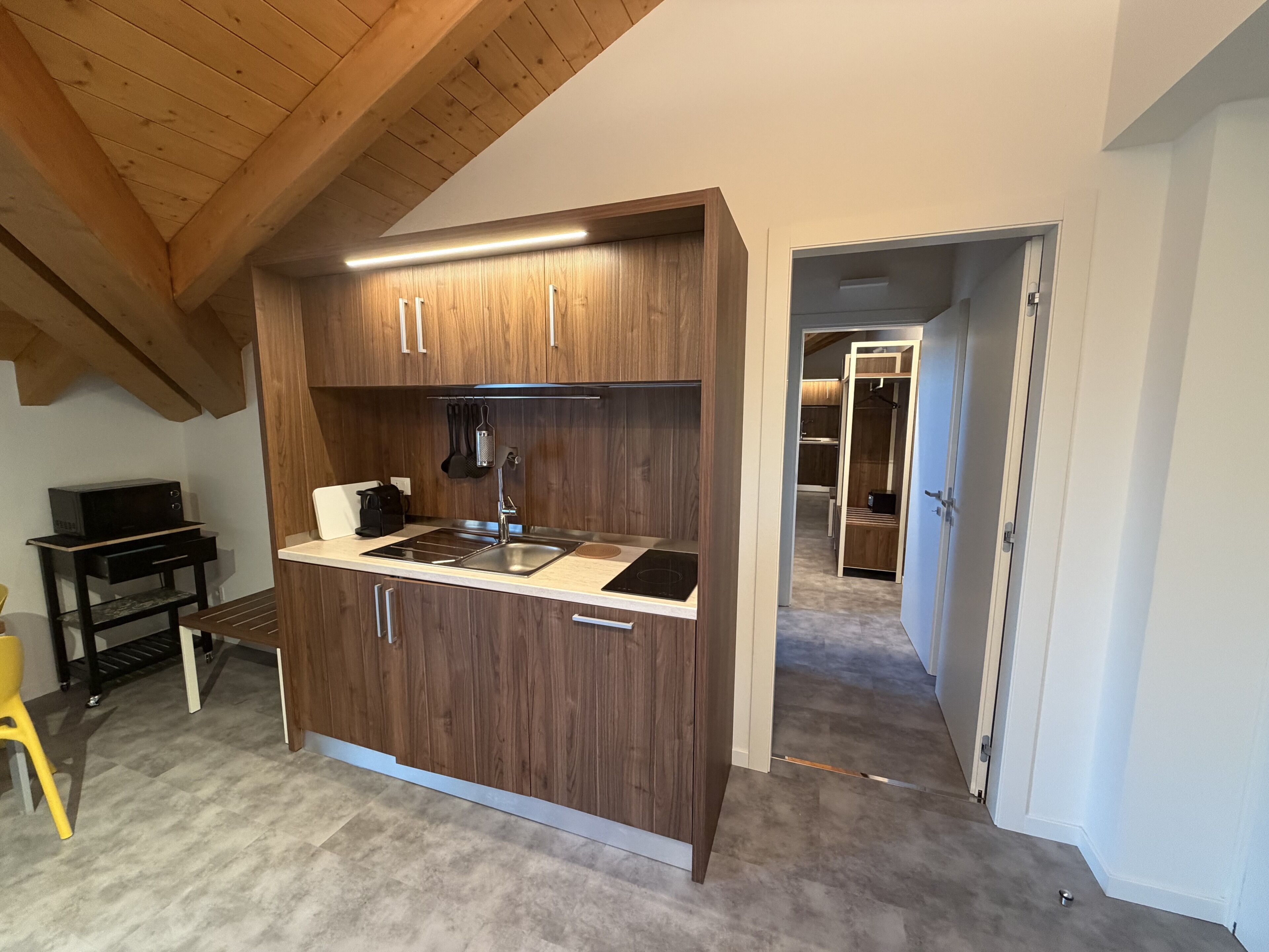A modern kitchen with wooden cabinets, a stainless steel sink, and a built-in stove.