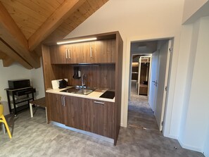 A modern kitchen with wooden cabinets, a stainless steel sink, and a built-in stove. - Mirage Arona (Arona)