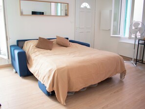 A bedroom with a bed, pillows, a mirror, a door, and a window. - La Seinette - Proche gare - Wifi (Argenteuil)