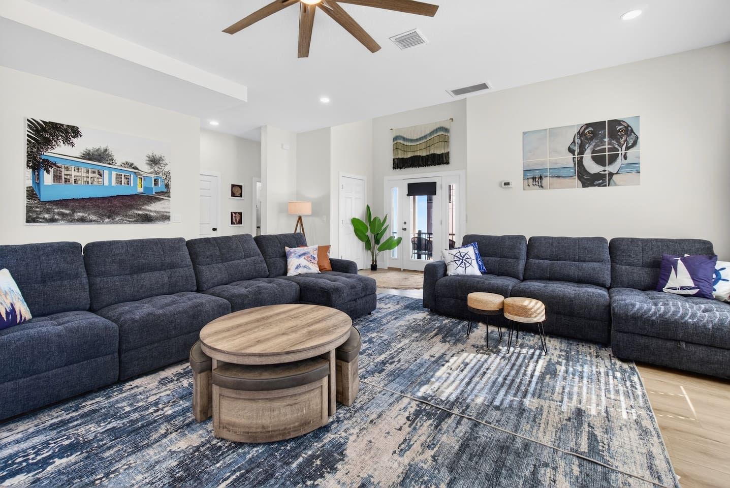 A modern living room with two grey sofas, a round wooden coffee table, and a patterned rug.