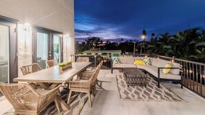 An outdoor patio with a dining table, chairs, and a sofa with cushions. - Spacious Beach Retreat, Sleeps 10 | Walk to Gulf (Redington Beach)