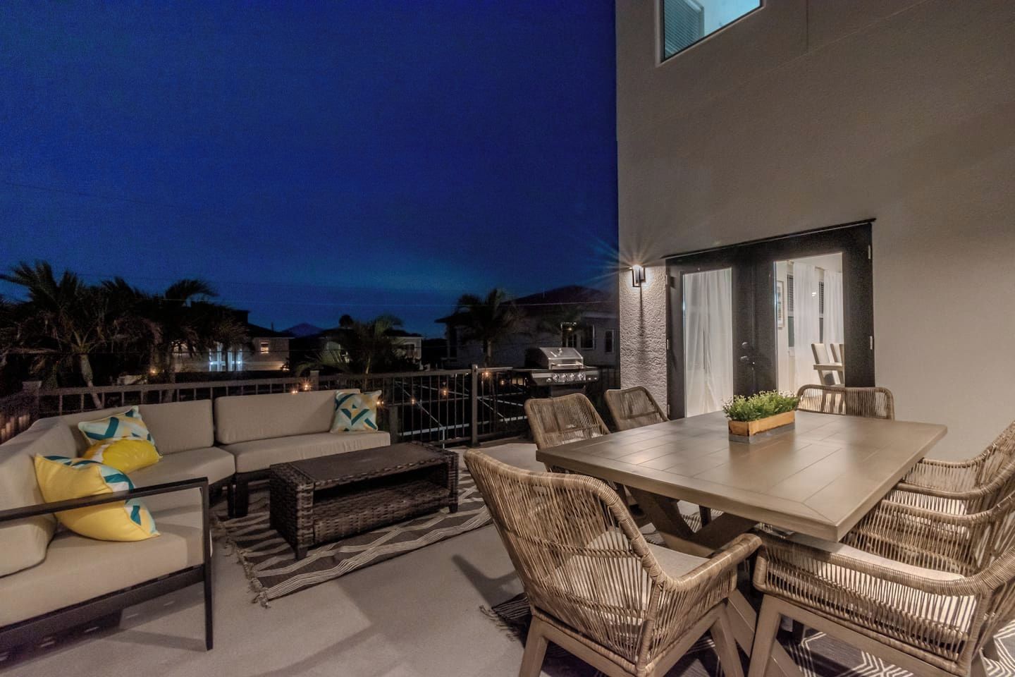 A rooftop patio with a dining table, chairs, and a sofa.